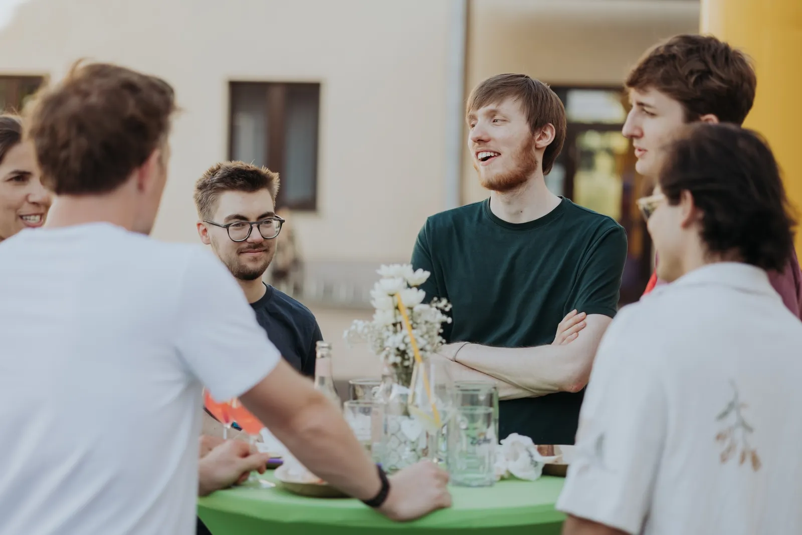 Kolleg:innen lachen gemeinsam an einem Tisch beim Sommerfest